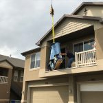 Professional piano movers using crane equipment to move a piano from an upper-floor home in Utah